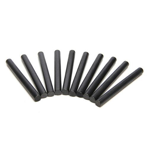 Een halve cirkel van tien zwarte houtskoolstokjes op wit weerspiegelt de "Ontsteek vuren overal! - 10-pack magnesium vuurstarters", klaar om je volgende buitenavonturen te ontsteken.