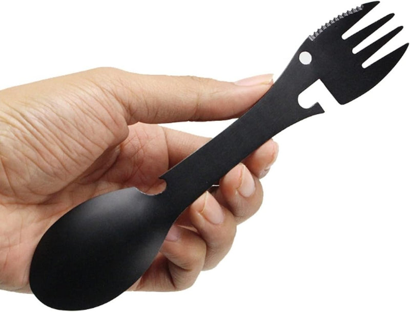 Laad afbeelding in Galerijviewer, Een hand omvat een strakke zwarte spork van roestvrij staal, met aan de ene kant een lepel en aan de andere kant een gekartelde vork - ideaal voor jouw behoeften met &quot;De ultieme multifunctionele kampeerlepel: Jouw beste vriend voor elk avontuur.

