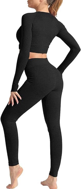 Laad afbeelding in Galerijviewer, Een persoon staat op blote voeten, met het gezicht van de andere kant af, en draagt een zwarte, versleten stoffen crop top met lange mouwen en een legging met hoge taille uit de 3-delige yoga-work-outset.
