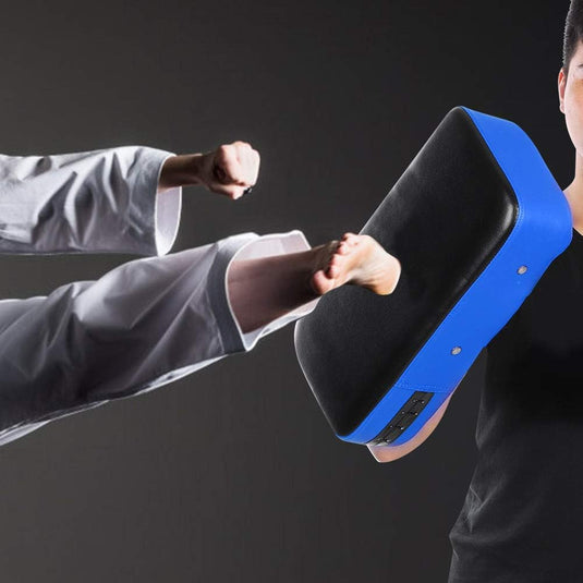 Een vechtsporter geeft een krachtige trap op het PU lederen stootkussen, ontworpen voor intensieve training, vakkundig vastgehouden door een andere liefhebber.