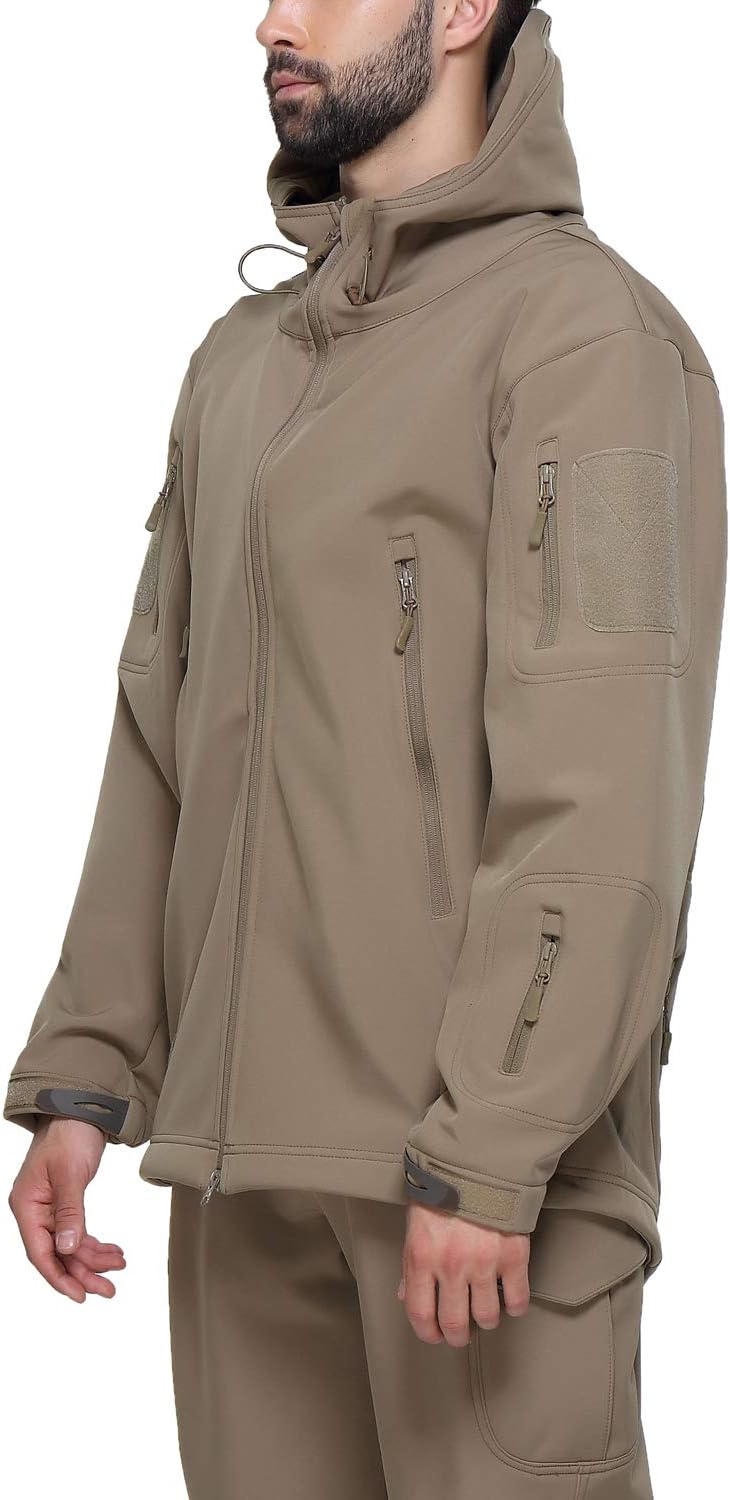 Laad afbeelding in Galerijviewer, Een persoon die een lichtbruin jack met capuchon draagt, meerdere zakken met ritssluiting en een bijpassende broek, zoals de Camouflage Tactische Heren Softshell Jas: de perfecte metgezel voor je outdooravonturen, ideaal voor wie op zoek is naar ademend comfort bij alle weersomstandigheden.
