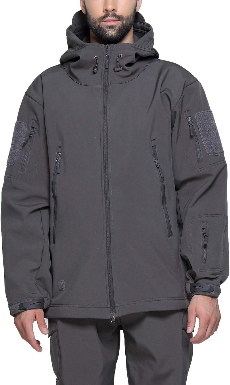 Laad afbeelding in Galerijviewer, Een persoon staat op een witte achtergrond en draagt de Camouflage tactische heren softshell jas, ideaal voor buitenavonturen, in donkergrijs met meerdere ritsen, zakken en een capuchon, gecombineerd met bijpassende broek.
