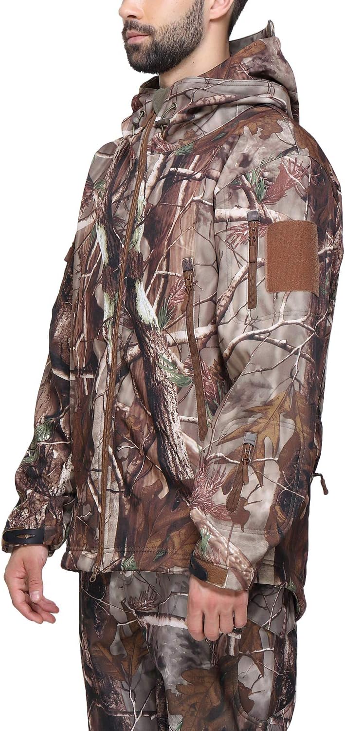 Laad afbeelding in Galerijviewer, Persoon in een camouflage tactische heren softshell jas, lichtjes rechts georiënteerd. De jas toont boom- en bladpatronen met meerdere zakken en ritsen, perfect samensmeltend stijl met functionaliteit voor outdooravonturen.
