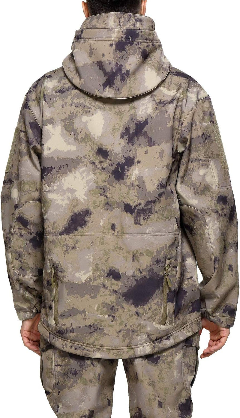 Laad afbeelding in Galerijviewer, Een achteraanzicht van iemand die de Camouflage tactische heren softshell jas en bijpassende broek met capuchon draagt, in een mix van groene, bruine en zwarte tinten.
