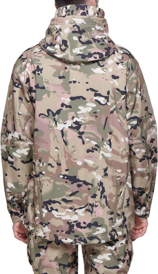 Een persoon gezien vanaf de rug, gekleed in een camouflage tactische heren softshell jas en broek in een mix van groene, bruine en beige tinten.