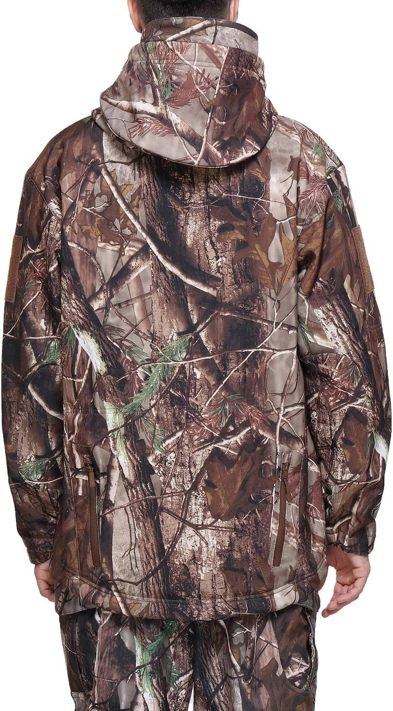 Laad afbeelding in Galerijviewer, Een persoon is van achteren te zien, gekleed in een Camouflage tactische heren softshell jas met een bosmotief, dat naadloos opgaat in de achtergrond van de natuur.
