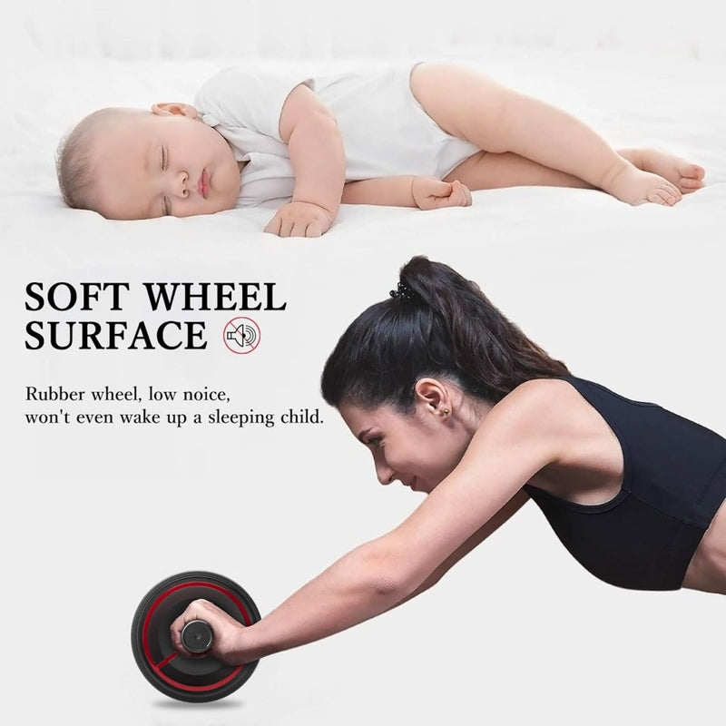 Laad afbeelding in Galerijviewer, Een vrouw gebruikt de &quot;Versterk je core met onze Ab-roller voor thuisfitness!&quot; terwijl er een baby in de buurt slaapt. Het zachte wieloppervlak en het lage geluidsniveau maken het de perfecte buikspiertrainer om je core te versterken zonder je kleintje te storen.
