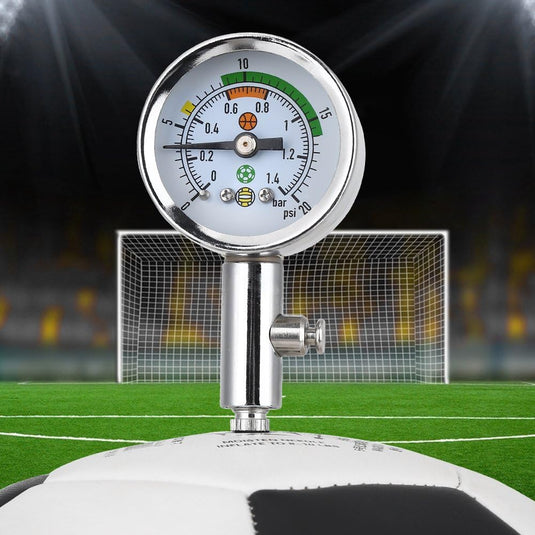 De "Optimaliseer je spel met onze mini luchtdrukmeter voor sportballen!" is bevestigd aan een voetbal met het doel op de achtergrond. Het geeft de druk weer in bar en psi, wat zorgt voor optimale prestaties tijdens het spel.