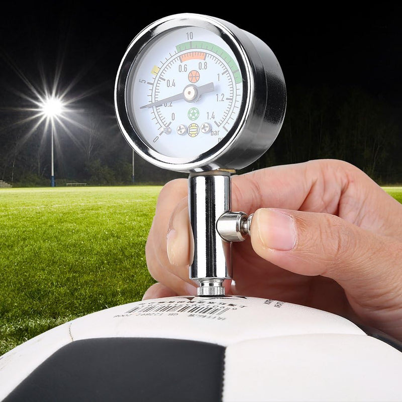 Laad afbeelding in Galerijviewer, Met de &quot;Optimaliseer je spel met onze mini luchtdrukmeter voor sportballen!&quot; controleert een hand &#39;s nachts de luchtdruk van een zwart-witte voetbal op het veld, om er zeker van te zijn dat de bal klaar is om mee te spelen.
