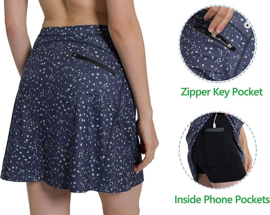 Een persoon die de Sportieve en stijlvolle golfskort voor dames draagt in marineblauw met witte patronen, met een sleutelzakje met ritssluiting aan de achterkant en telefoonzakken aan de binnenkant. Gemaakt van elastisch materiaal voor comfort, het is een ideale keuze in damessportkleding.