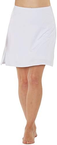 Een persoon modelleert een effen witte knielange rok die doet denken aan klassieke damessportkleding, vergelijkbaar met de Sportieve en stijlvolle golfskort voor dames, die blootsvoets tegen een eenvoudige achtergrond staat.