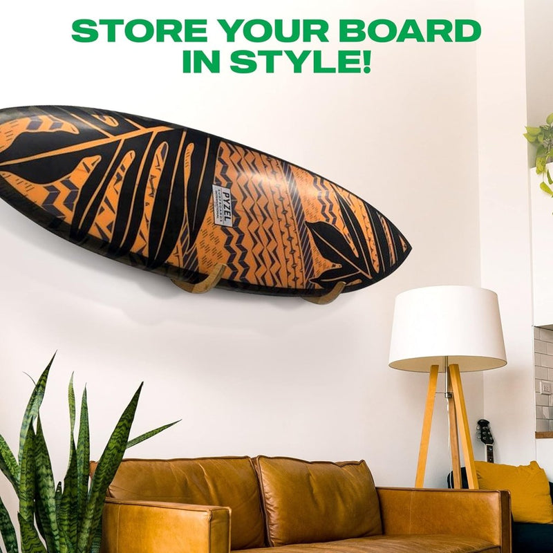 Laad afbeelding in Galerijviewer, De &quot;Jouw surfplank verdient een stijlvolle display! 🏄‍♂️&quot; hangt aan een witte muur boven een bruine leren bank met een staande lamp en een hoge plant ernaast. De tekst bovenaan luidt: &quot;STORE YOUR BOARD IN STYLE!.

