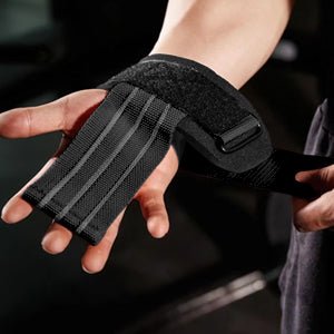 Laad afbeelding in Galerijviewer, Close-up van een hand met de Stevige-hefriemen voor maximale kracht en ondersteuning. Gemaakt van zwarte stof met klittenbandsluitingen en grijze lijnen, ideaal voor krachttraining.

