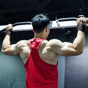 Laad afbeelding in Galerijviewer, Een persoon die &quot;Stevige hefbanden voor maximale kracht en ondersteuning&quot; gebruikt in een rode tanktop, voert een pull-up uit in een sportschool, van achteren gezien, waarbij zijn gespierde armen en rug zichtbaar zijn tijdens krachttraining.
