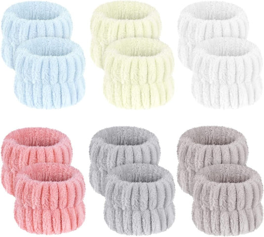 Acht elastische polsbandjes voor gezichtsverzorging, gemaakt van microvezelmateriaal, in paren van blauw, groen, wit, roze en grijs. Ze zijn perfect gerangschikt in twee rijen en ideaal voor yoga- en make-uproutines.