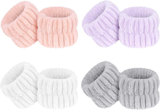 Twee rijen van vier paar elastische polsbanden voor gezichtsverzorging in de kleuren roze, paars, wit en grijs worden weergegeven op een effen witte achtergrond.