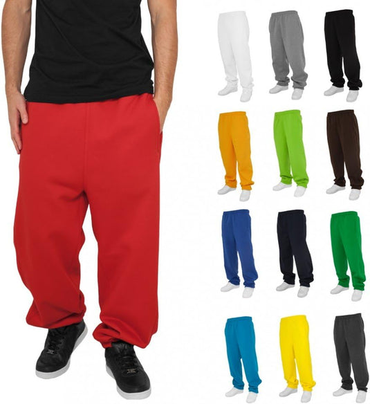 Het dragen van loszittende rode joggingbroeken en zwarte schoenen geeft een relaxte uitstraling. Rechts toont een display van Comfortabele en stijlvolle joggingbroeken voor heren in verschillende kleuren hun veelzijdigheid voor elk casual uitje.