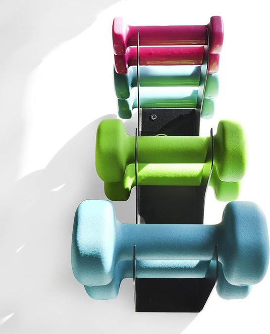 Drie kleurrijke halterparen – roze, groen en blauw – worden tentoongesteld op een modern, Europees ontworpen zwart koolstofstalen rek met de naam ‘Ontdek de kracht van onze moderne koolstofstalen halters wandhouder’, tegen een witte achtergrond.