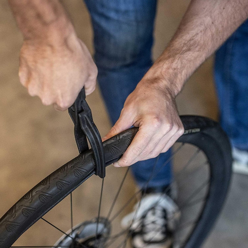 Laad afbeelding in Galerijviewer, Met behulp van onze &quot;Maak het wisselen van banden eenvoudig met onze bandentang voor fietsen!&quot; verwijdert de persoon moeiteloos de fietsband, waarbij een universele pasvormtechniek wordt getoond voor het eenvoudig verwisselen van banden.
