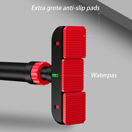 Close-up van het hulpmiddel "De optrekstang die je thuis een complete workout geeft" met drie grote rode antislipkussentjes, gemaakt van hoogwaardig staal, en een zichtbare groene nivelleerbubbel. Gelabeld in het Nederlands: "Extra grote antislippads" en "Waterpas".