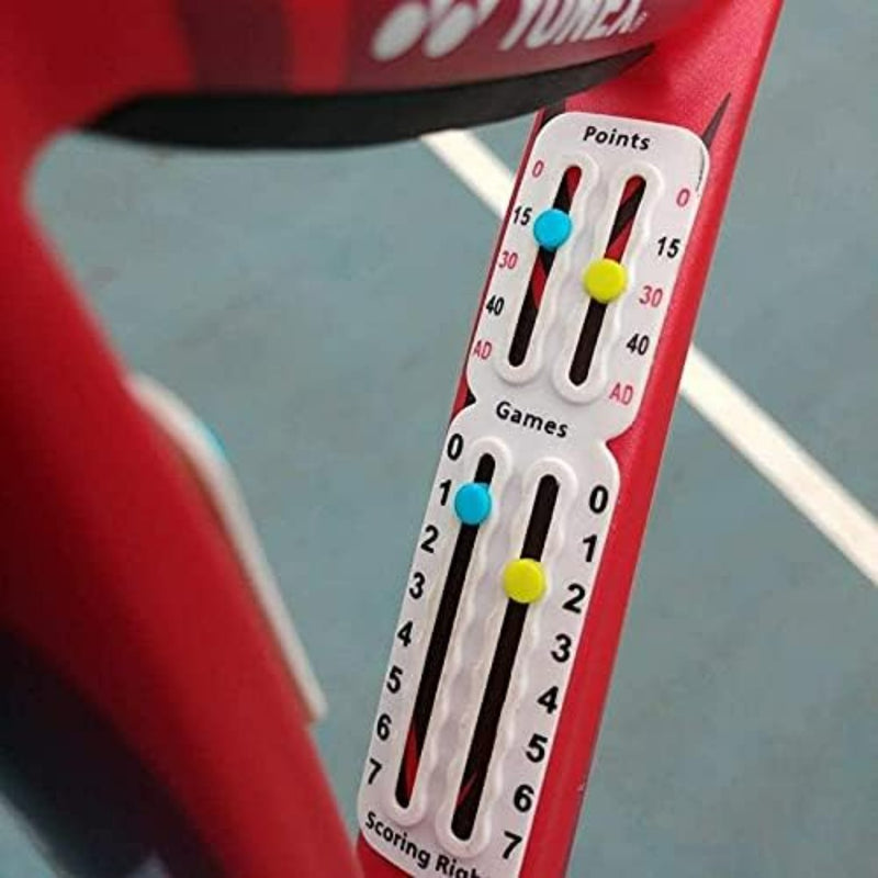 Laad afbeelding in Galerijviewer, Close-up van een Draagbaar tennis scorebord op een rood racket, met punten en spellen met gekleurde pinnen op genummerde tracks. De baanlijnen zijn zichtbaar op de achtergrond, wat de compatibiliteit met elk universeel montagesysteem laat zien.
