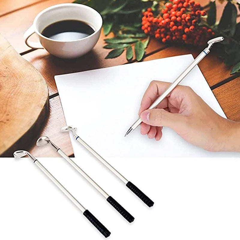 Laad afbeelding in Galerijviewer, Schrijven op papier met een pen uit de Golfclub pennenset, samen met drie bijpassende pennen en een koffiekopje op een houten oppervlak, met rode bessen en groene bladeren op de achtergrond.
