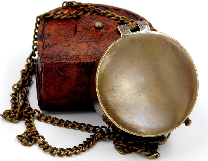 Laad afbeelding in Galerijviewer, Een handgemaakt zakkompas van messing, compact en lichtgewicht, met een lange ketting, rust op een getextureerd bruin leren etui versierd met sterpatronen.
