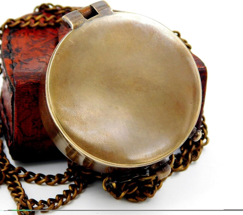 Laad afbeelding in Galerijviewer, Een zorgvuldig vervaardigde handgemaakte messing zakkompas, een klassieke must-have voor buitenliefhebbers, met een ketting die rust op een gestructureerd, bruin oppervlak.
