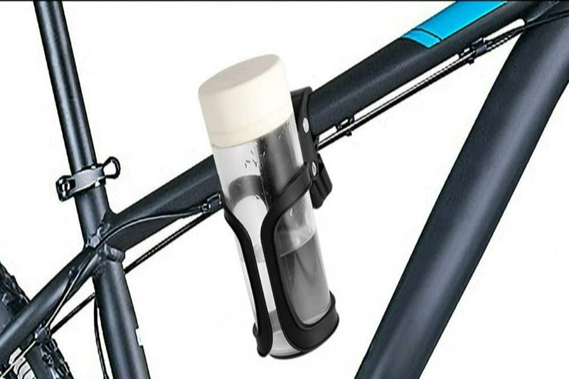 Laad afbeelding in Galerijviewer, Een waterfles met een witte dop is in een Happygetfit bidonhouder zonder schroeven op het frame van een strakke zwarte fiets bevestigd.

