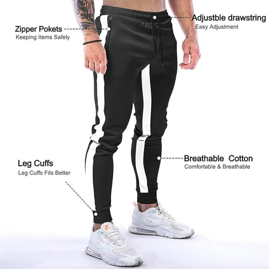 Een persoon die een stijlvolle joggingbroek voor heren draagt met witte strepen, ritszakken, verstelbaar trekkoord en pijpmanchetten. Gemaakt van versleten katoen voor extra comfort, ze passen perfect bij zichtbare witte sneakers.