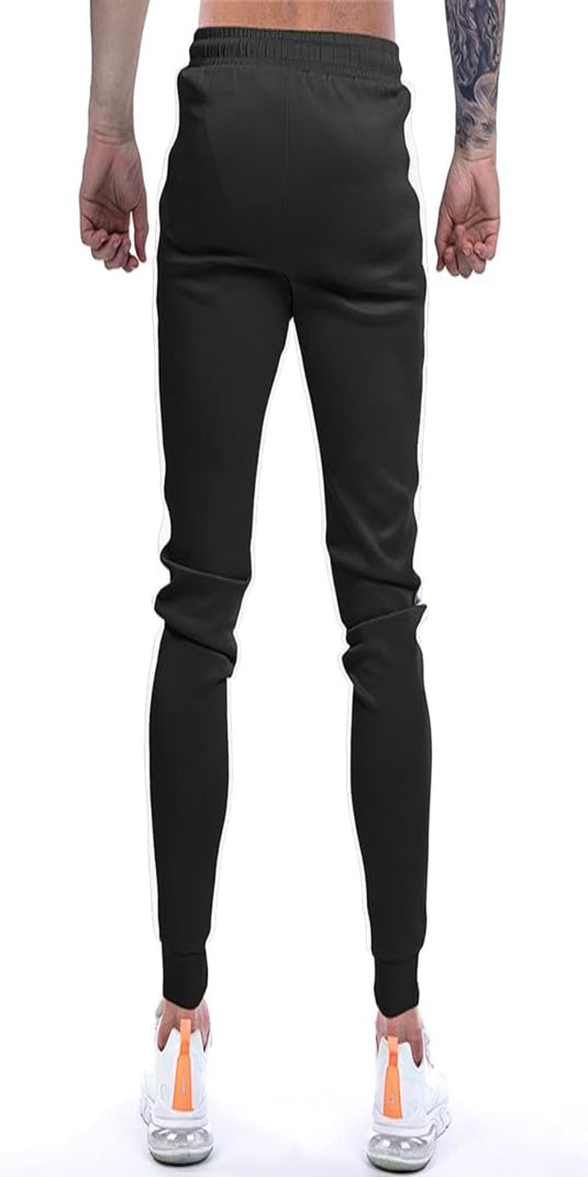 Een man met zijn rug naar de camera showt zijn Joggingbroek voor heren in het zwart, gecombineerd met witte sneakers met oranje accenten voor een stijlvolle uitstraling.
