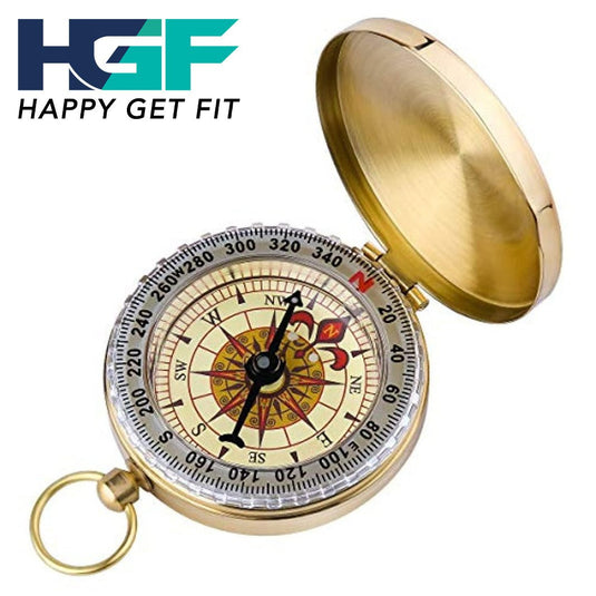 Een goudkleurige Happygetfit zakkompas, voorzien van een decoratief gezicht en richtingaanwijzers, ligt open. Dit veelzijdige navigatiegereedschap toont een logo met de tekst "HAPPY GET FIT" in de linkerbovenhoek.