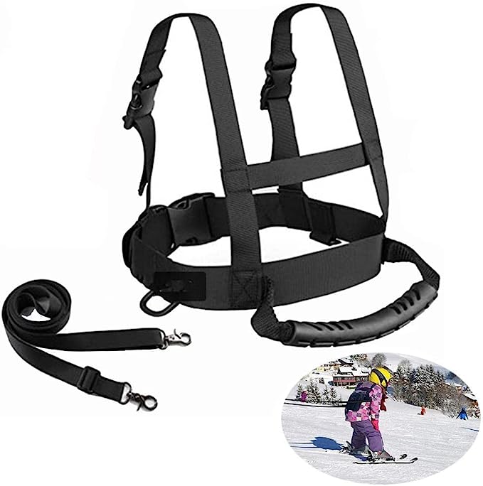 Laad afbeelding in Galerijviewer, Het &quot;Optimaal begeleid&quot; skituigje heeft verstelbare bandjes en een afneembare riem, zoals te zien is op de inzet van een kind met helm dat veilig skiet met kleurrijke kleding. Perfect voor spannende wintersportavonturen!.
