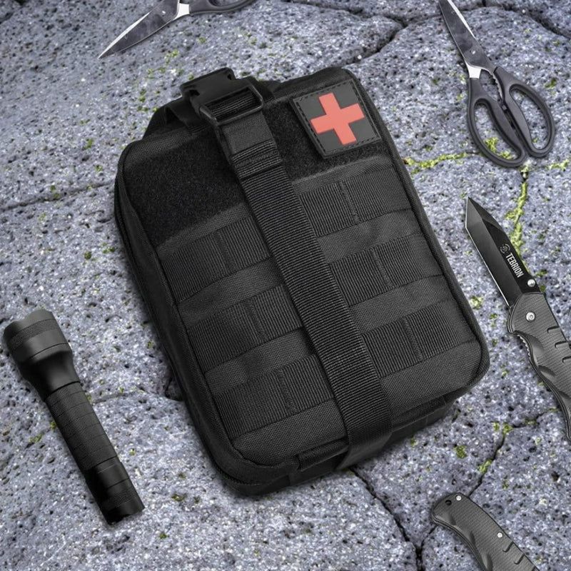 Laad afbeelding in Galerijviewer, Een zwarte EHBO-kit met een rood kruis staat op een grijs oppervlak, vergezeld door een schaar, een zaklamp en messen. Gemaakt van duurzaam 600D nylon en waterdicht, past het perfect in je tactische heuptas &quot;Ontdek de ultieme metgezel voor avonturiers&quot;, klaar voor elk avontuur.
