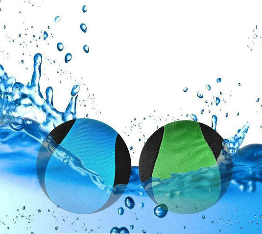 Twee zwartomrande ronde inzetstukken met blauwe en groene gedeelten zweven moeiteloos tegen een waterspattende achtergrond en lijken op levendige Waterballen: een filmwaterpret voor het hele gezin in een serene zwembadomgeving.