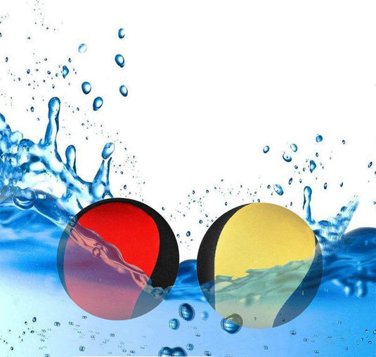 Twee levendige ronde waterballen, een rode en een gele, liggen half ondergedompeld in opspattend water op een witte achtergrond – ideaal voor kinderen die genieten van speelplezier in het zwembad. Product: Waterballen: een locatie waterpret voor het hele gezin.
