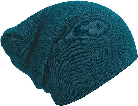 Een blauwgroen gebreide muts, gemaakt van zachte luxe stoffen, heeft een modieuze slouchy stijl tegen een witte achtergrond en is te zien in "Slouch beanies: de perfecte wintermuts voor dames en heren.