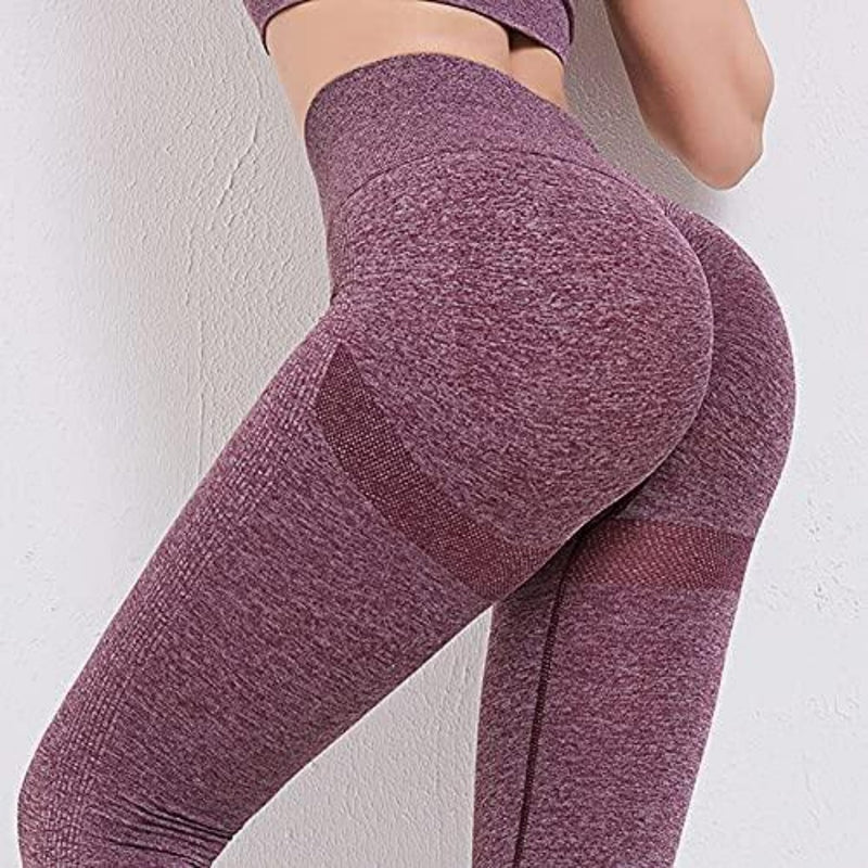 Laad afbeelding in Galerijviewer, Een persoon draagt een kastanjebruine yogalegging en bijpassend topje, waarbij zijn rug tegen een effen muur rust.
