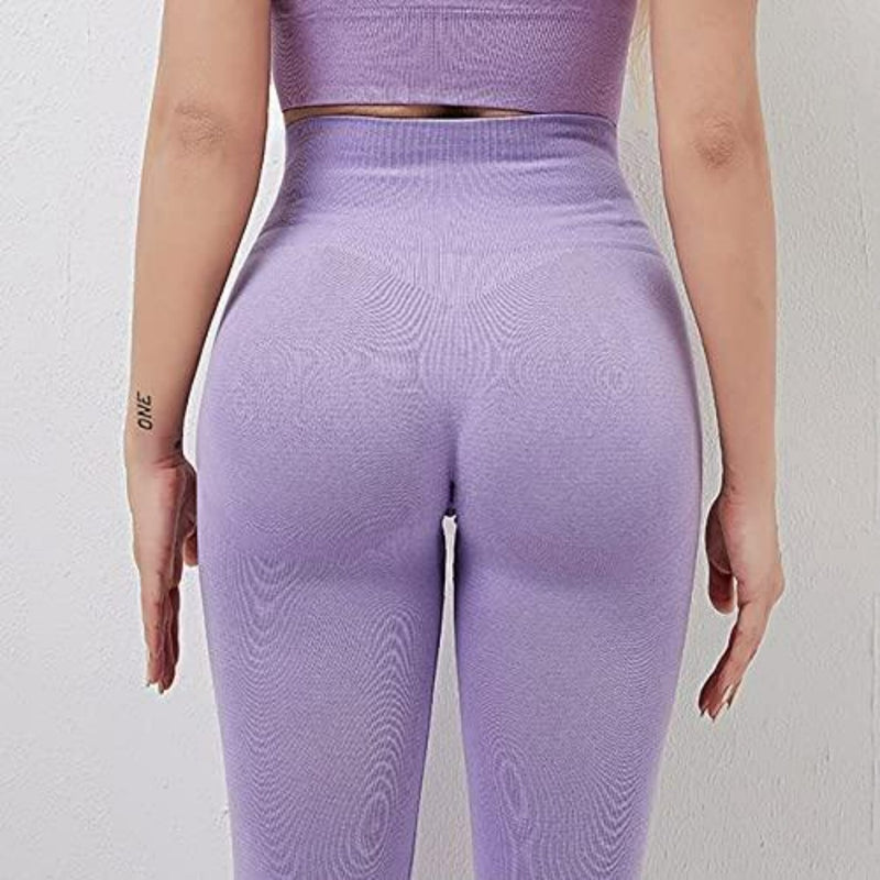 Laad afbeelding in Galerijviewer, Iemand die een paarse atletiekoutfit draagt, inclusief onze &quot;Ontdek de perfecte balans van stijl en comfort met onze yogaleggings voor dames!&quot; met hoge tailleband, is van achteren tegen een lichte muur gefotografeerd.
