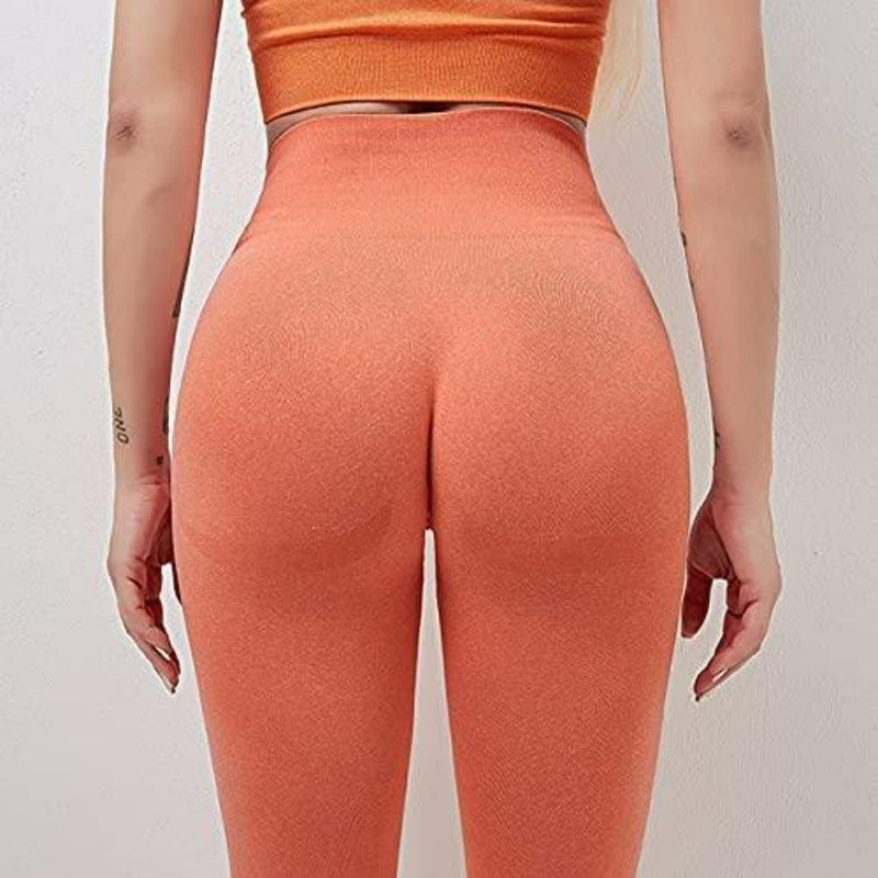 Laad afbeelding in Galerijviewer, Een persoon in oranje sportkleding, van achteren gezien, kijkt naar een witte muur en toont onze stijlvolle en comfortabele yogaleggings voor vrouwen met een hoge tailleband.
