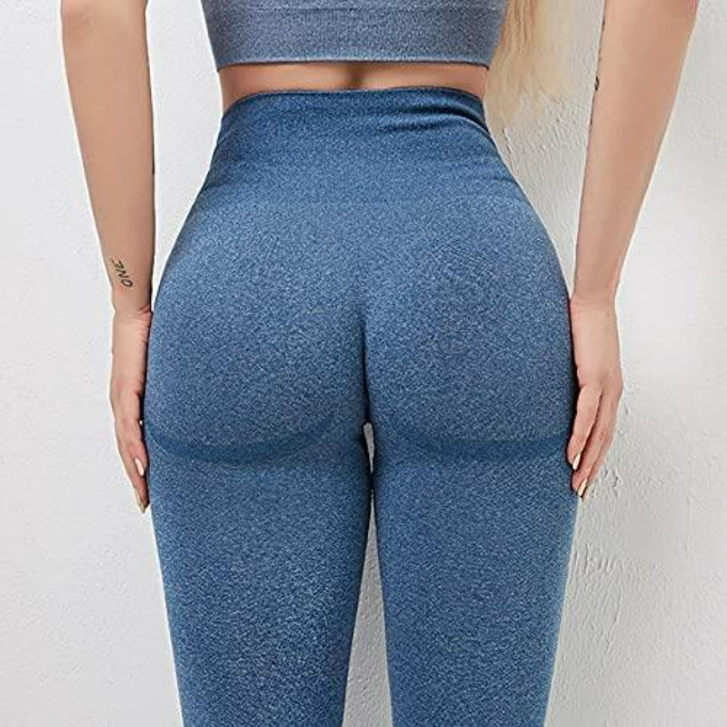 Laad afbeelding in Galerijviewer, Een persoon die &quot;Ontdek de perfecte balans van stijl en comfort met onze yogaleggings voor dames draagt!&quot; in blauw vanaf de achterkant, met accent op een hoog getailleerde tailleband, met handen op de heupen en een tatoeage op de linkerpols.
